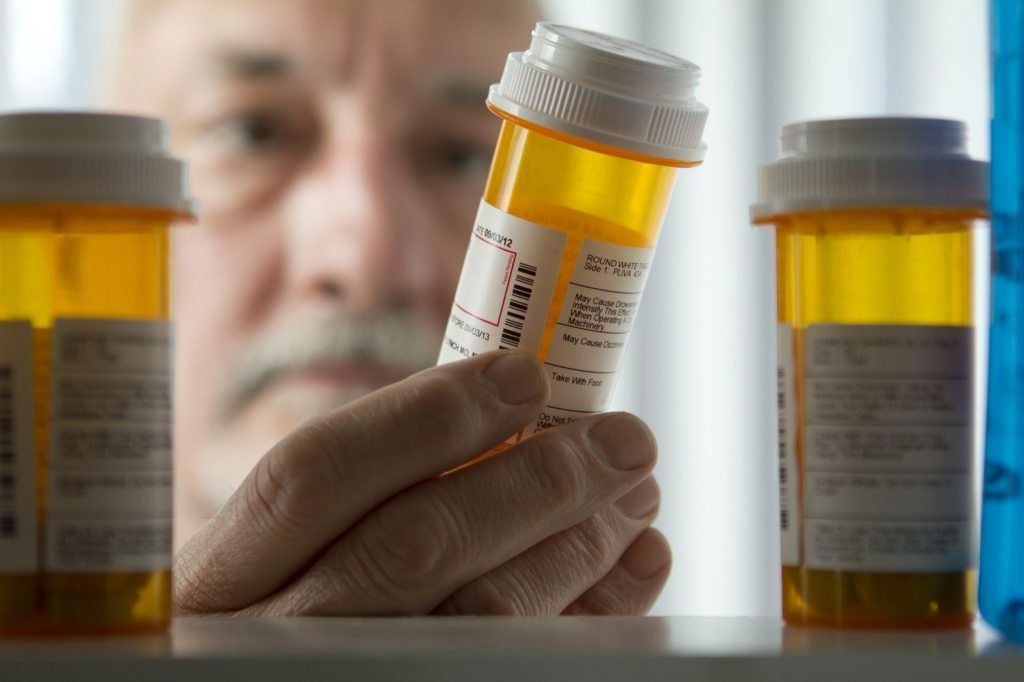 Man reaching for prescription form medicine cabinet